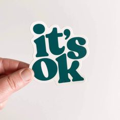 someone holding up a sticker that says it's ok