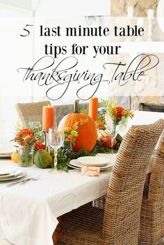 a table set for thanksgiving dinner with pumpkins and greenery on the table, surrounded by wicker chairs