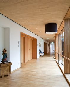 a long hallway with wooden floors and white walls, leading to the second floor area