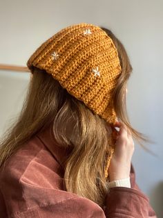 a woman wearing a yellow knitted hat with stars on the front and back side