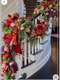 the stairs are decorated with christmas garlands and flowers on each handrail, along with other holiday decorations