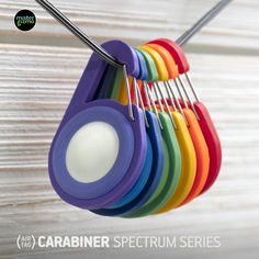 there is a rack with different colored spoons hanging from it