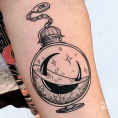 a black and white photo of a tattoo design on the right thigh, with an image of a moon in a glass ball