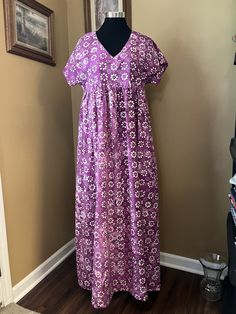 "This is a hand crafted maxi dress with a high empire waist, v neck and a full gathered skirt.  It is made of a lovely tropical looking purple batik, cotton fabric. It has a nice casual look for home, lunch date, hanging out at the beach or even to wear on a cruise. It is a ladies size large, 14-16.  Please, review the measurements for the size below to check the fit, before ordering. Bust size 36-38. Hip size 38-40. Length of the dress is about 56 1/2\" long.  This measurement is taken from the Empire Waist Floral Print Maxi Dress For Beach, Floral Print Maxi Dress With Empire Waist, Bohemian Empire Waist Maxi Dress For Beach, Bohemian Empire Waist Maxi Dress For Vacation, Bohemian Maxi Dress With Empire Waist For Vacation, Summer V-neck Maxi Dress With Batik Print, V-neck Floral Print Maxi Dress Beach Cover-up, Cotton V-neck Sundress Maxi Dress, Flowy Empire Waist Sundress