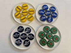 four glass plates filled with different types of buttons