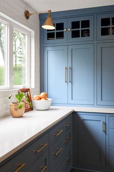 a kitchen with blue cabinets and white counter tops