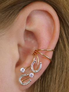 What is not to love about this gorgeous Horseshoe non*pierced ear cuff! The horseshoes are delicate but very detailed, and accented by two cubic zirconia to add a little variation and pizzazz . It fits gracefully up the natural shape of your ear with shimmer and pizzazz! This earring requires no piercing and sit securely in the center of your ear. We use only the highest quality materials Sterling Silver and 14K Gold Filled. This piece will arrive in a Gift Box and include simple fitting instruc Ear Cuff Gold, Horse Ears, Ear Crawler, Country Jewelry, Pierced Ear, Ear Crawlers, Ear Climber, Wrap Earrings, Gold Ear Cuff