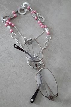 A very handy necklace to wear, this also doubles up as an Eye Glass Necklace.  Great gift for the lady who has everything.  The necklace measures 30 inches  (77 cm) long. If a  shorter or longer length is desired, please convoy me and I will do my best to accommodate you. I have used 8mm pink pearl glass beads, together with silver spacers and silver round links.  The glasses holder ring measures 35mm outside diameter.  The inside diameter of the silver ring is 30mm.  Please check the width of y Eye Glass Chain, Pearl Necklace Pink, Glasses Necklace, Pink Pearl Necklace, Glasses Holder, Eye Glass, Pearl Jewellery, Emo Outfits, Pink Jewelry