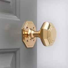 a close up of a door handle on a white door with gold hardware and knobs