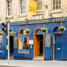 the world's end restaurant is painted blue and has flower boxes on the front