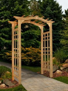 an outdoor wooden arbor in the middle of a garden