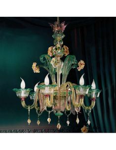 a fancy chandelier hanging from the ceiling in a room with dark walls and curtains