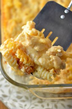 a fork full of macaroni and cheese being lifted from the casserole dish