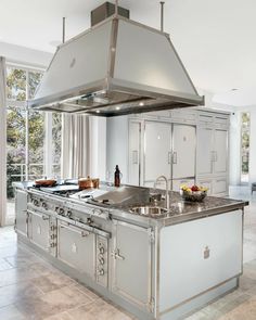 a large kitchen with stainless steel appliances and an island in the middle is pictured here