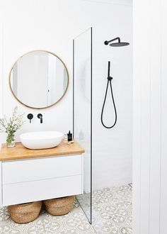 a bathroom with a sink, mirror and shower head in it's center area