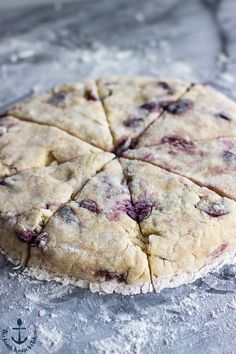 an uncooked berry pie sitting on top of a baking sheet covered in powdered sugar