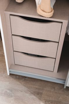 a close up of a dresser with drawers and a stuffed animal on it's side