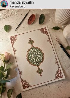 a card with an intricate design on it next to some flowers and other crafting supplies