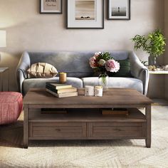 a living room with a couch, coffee table and two framed pictures on the wall