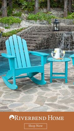 two adiron chairs sitting next to each other on a stone patio with water fall in the background