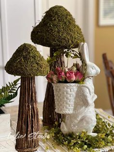 the table is decorated with moss and flowers in vases on top of each other