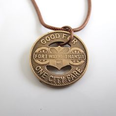 "A unique necklace that I made with an original Fort Wayne Transit token.  You can choose form the solid bronze version (this token was first used in 1950) or the silver tone (first used in the 1940's).  The silver tone doesn't read Fort Wayne; only Indiana on it.  I lightly polished the token to bring out the writing and color.  The first two photos show both types.  5/8\" in diameter.  The chain is an antiqued bronze tone or silver tone with nice lobster claw clasp (you can choose 18\" or 20\" length).  It will come in a new gift box and the one in the photos will be the exact token you receive.  If you need more than one, please let me know.  I also have other Fort Wayne token jewelry in my shop: www.etsy.com/shop/lucra?ref=shop_sugg&search_query=fort+wayne I can usually fill larger ord Retro Medallion Necklace With Vintage Charm, Vintage Charm Brass Jewelry In Retro Style, Retro Brown Necklace For Gift, Vintage Coin-shaped Brass Necklaces, Vintage Coin Shaped Medallion Necklace, Vintage Brass Coin Necklaces, Vintage Charm Brass Necklace In Retro Style, Retro Brass Necklace With Vintage Charm, Vintage Brown Nickel-free Necklace