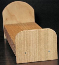 a small wooden chair sitting on top of a table next to a black wall and floor