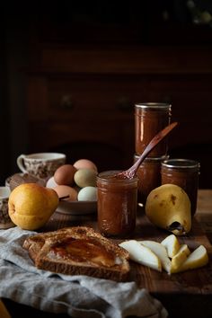 apples, pears and peanut butter are on a table with other food in jars