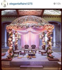 the wedding stage is decorated with white flowers and pink draping for an elegant touch