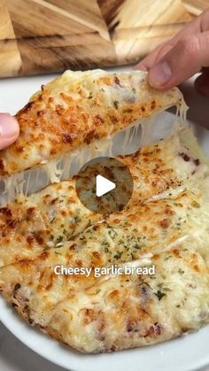 someone is cutting into a cheesy garlic bread pizza on a plate with a knife