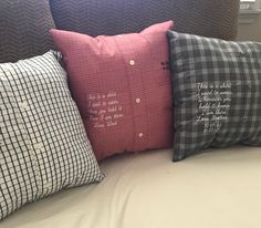 three decorative pillows on top of a bed with white sheets and black checkered pillow cases