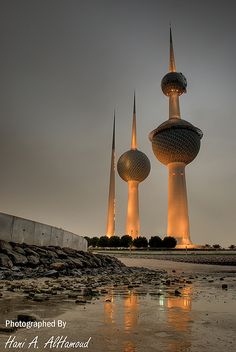 two very tall buildings sitting next to each other on top of a beach near the ocean