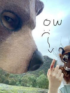 a woman is touching the nose of a stuffed animal that looks like a dog's head