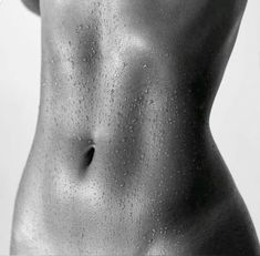 a black and white photo of a woman's body with water droplets on it