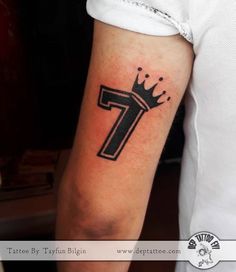 a man with a tattoo on his arm that has the letter t in black ink