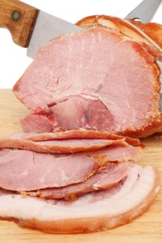 sliced ham sitting on top of a cutting board next to an instant pot roaster