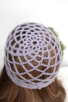 a close up of a woman's head wearing a crocheted hair piece