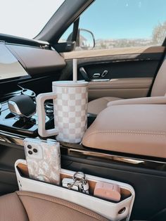 the interior of a car with two coffee mugs and cell phone holders in it