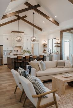 a living room filled with furniture next to a kitchen