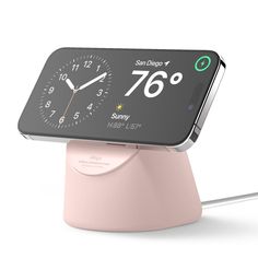 an alarm clock on top of a pink stand