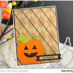 a close up of a card with a pumpkin on it and some candy in the background