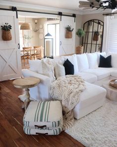 a living room filled with white furniture and lots of pillows on top of it's couches