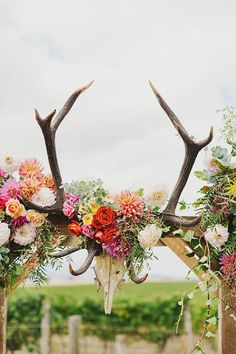 the antlers are adorned with flowers and greenery