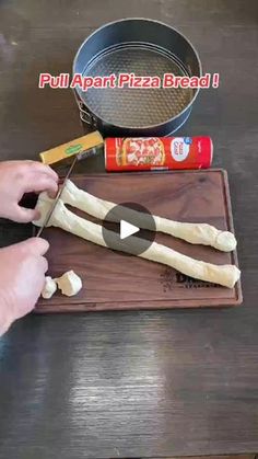 a person cutting up some food on top of a wooden table with a spatula