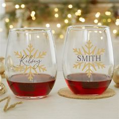 two wine glasses sitting next to each other on top of a table with christmas decorations