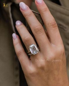 a close up of a person's hand with a diamond ring on their finger