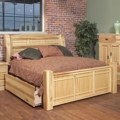 a bedroom with a bed, dresser and mirror in the corner next to a brick wall