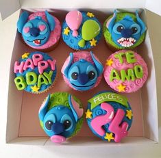 there are twelve cupcakes in the box decorated with cartoon characters and numbers for each child's birthday