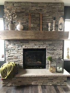 a living room with a stone fireplace and wooden floors