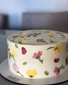 a white cake with yellow and pink flowers on it